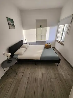 a bedroom with a large bed and a wooden floor at Blife Troya private rooms at Faro beach in Faro