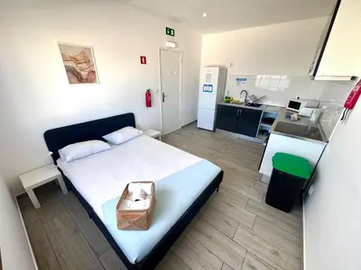 a bedroom with a bed with a bag on it at Blife Troya private rooms at Faro beach in Faro