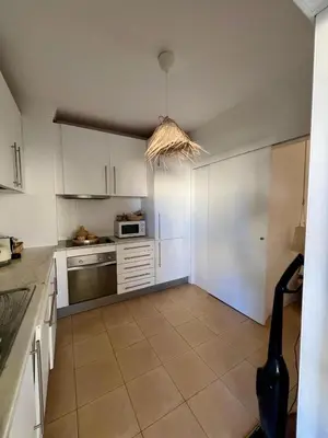 a kitchen with white cabinets at Salgados Studio in Guia