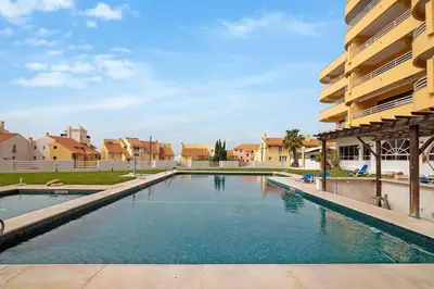 a swimming pool in front of a building at Marina Mar in Vilamoura