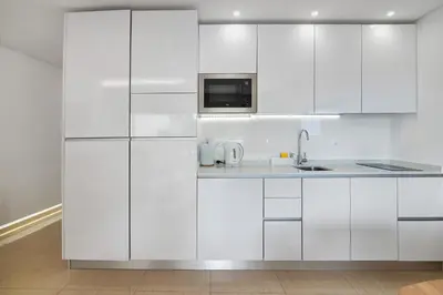 a white kitchen with white cabinets and a sink at Marina Mar in Vilamoura