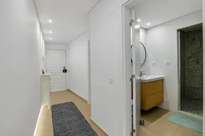 a white bathroom with a shower and a sink at Marina Mar in Vilamoura