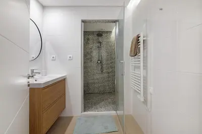 a white bathroom with a shower and a sink at Marina Mar in Vilamoura