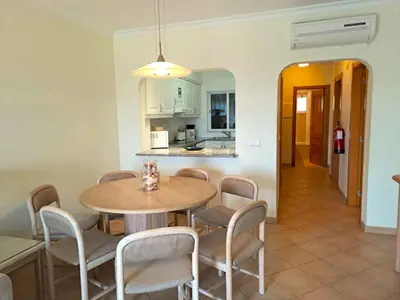 a kitchen and dining room with a table and chairs at Superior Two Bedroom Apartment in Clube Albufeira in Albufeira