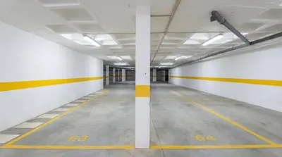 an empty parking garage with yellow and white walls at Bright 2BR with Pool near Beach by LovelyStay in Albufeira