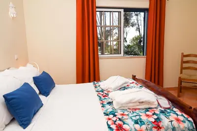 a bedroom with a bed with blue pillows and a window at Villa Simões by Delilah Collection in Albufeira