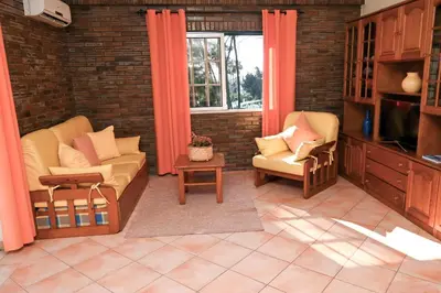 a living room with two chairs and a tv at Villa Simões by Delilah Collection in Albufeira