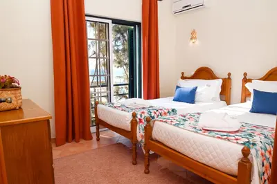 a bedroom with two beds and a window at Villa Simões by Delilah Collection in Albufeira