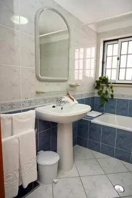 a bathroom with a sink and a toilet and a mirror at Villa Simões by Delilah Collection in Albufeira