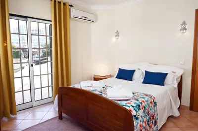 a bedroom with a bed with blue pillows at Villa Simões by Delilah Collection in Albufeira