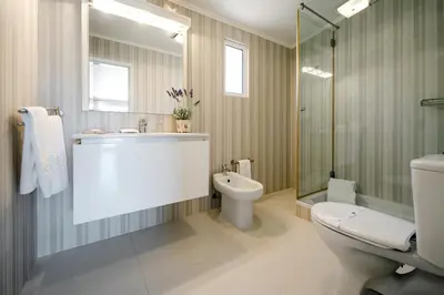a bathroom with a toilet and a sink and a shower at Sunrise Beach Villa by Delilah Collection in Albufeira