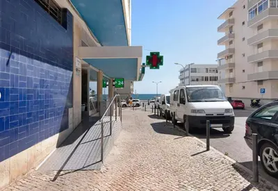 a white van parked on a street next to a building at VIP T2 Beachfront with Garage in Quarteira
