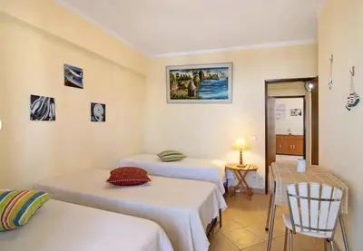 a room with two beds and a table and chairs at VIP T2 Beachfront with Garage in Quarteira