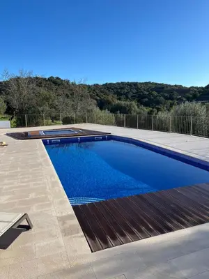 a swimming pool with blue water in a yard at Quinta do Olival - Casa Faro Oeste - Calm & wellness in São Brás de Alportel