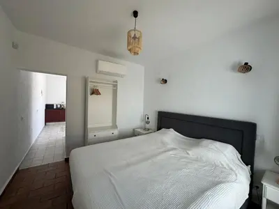 a bedroom with a white bed and a mirror at Quinta do Olival - Casa Faro Oeste - Calm & wellness in São Brás de Alportel