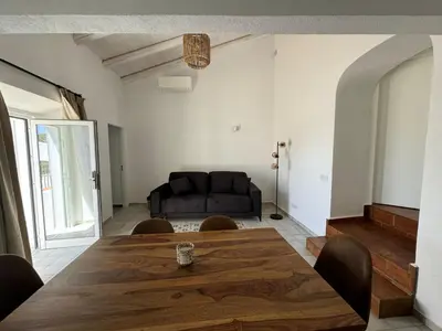 a living room with a wooden table and a couch at Quinta Do Olival - Casa Figueira - Calm & wellness in São Brás de Alportel