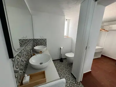 a bathroom with two sinks and a toilet at Quinta do Olival - Casa Limão - Calm & wellness in São Brás de Alportel