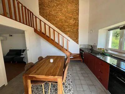 a kitchen with a wooden table and a staircase at Quinta do Olival - Casa Limão - Calm & wellness in São Brás de Alportel