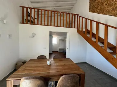 a dining room with a wooden table and a staircase at Quinta do Olival - Casa Limão - Calm & wellness in São Brás de Alportel