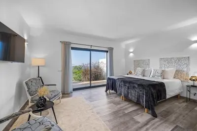 a white bedroom with a bed and a large window at Amazing Views Villa in Loulé