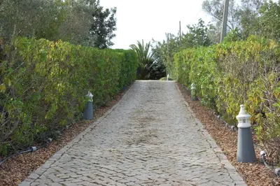 a patio with chairs and a table and an umbrella at Villa Monte Alegrete with sea view in Faro