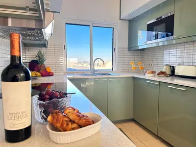 a bottle of wine and a bowl of food in a kitchen at WindMill Rooftop Panoramic OceanView Condo By BeCherish in Albufeira