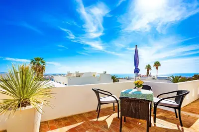a balcony with a table and chairs and the ocean at WindMill Rooftop Panoramic OceanView Condo By BeCherish in Albufeira