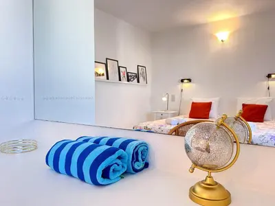 a room with two beds and a mirror at WindMill Rooftop Panoramic OceanView Condo By BeCherish in Albufeira