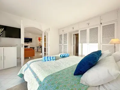 a bedroom with a large bed with blue and white pillows at WindMill Rooftop Panoramic OceanView Condo By BeCherish in Albufeira