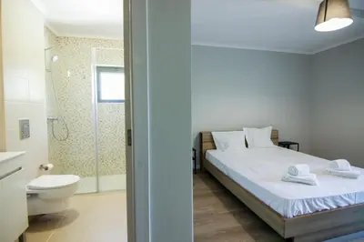 a bedroom with a bed and a toilet and a shower at QUANICE - Relaxing Guest House in Faro in Faro