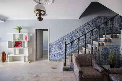 a living room with a staircase with blue and white tiles at QUANICE - Relaxing Guest House in Faro in Faro