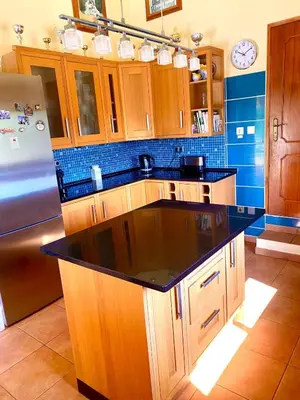 a kitchen with wooden cabinets and a black counter top at Casa Mariano Private Heated Pool With Views and AC