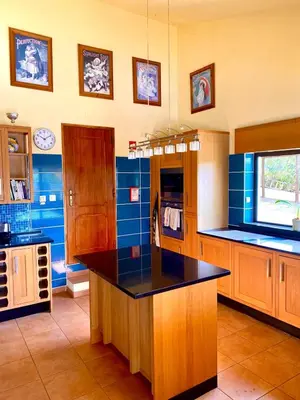 a large kitchen with blue walls and a black counter top at Casa Mariano Private Heated Pool With Views and AC