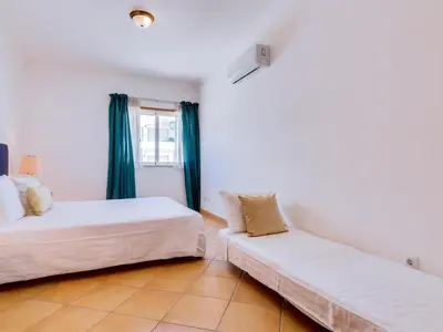 a bedroom with two beds and a couch at Colina Beach Holidays, 2 bdr Apartment Quarteira in Quarteira