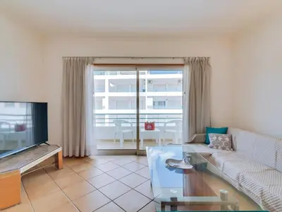 a living room with a couch and a tv at Colina Beach Holidays, 2 bdr Apartment Quarteira in Quarteira