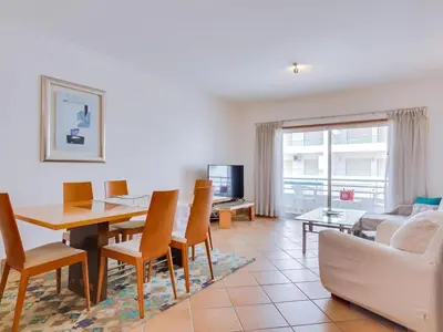 a living room with a table and a couch at Colina Beach Holidays, 2 bdr Apartment Quarteira in Quarteira