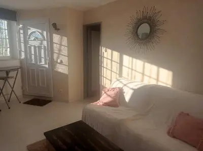 a living room with a white couch and a mirror at Casa Olivier in Loulé