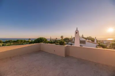 a balcony with a view of the ocean and a lighthouse at Casa da Praia in Galé