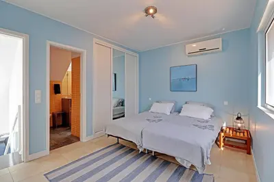a bedroom with a bed and a blue wall at Terras Novas Albufeira in Albufeira