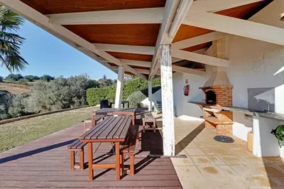 a wooden deck with a picnic table and a fireplace at Terras Novas Albufeira in Albufeira