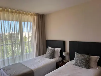 a bedroom with two beds and a large window at Vila das Lagoas 9A 3D in Guia