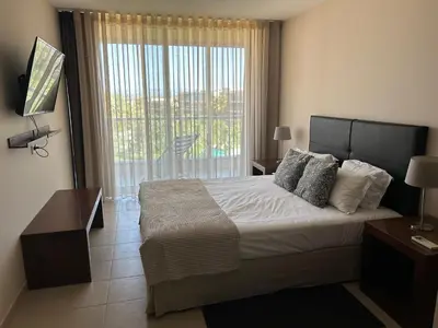 a bedroom with a large bed and a balcony at Vila das Lagoas 9A 3D in Guia