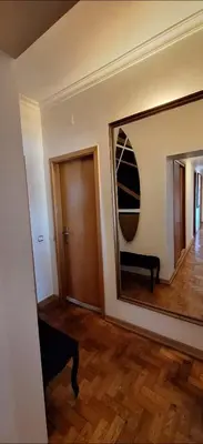 a living room with a mirror and a wooden floor at Location la vue sur mer in Albufeira