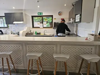 a man standing at a counter in a kitchen at Blife Sunya private rooms near airport and nature in Faro