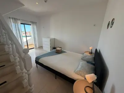 a bedroom with a large bed and a staircase at Blife Sunya private rooms near airport and nature in Faro