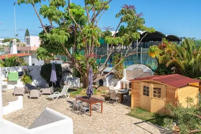 a backyard with a house and a table and chairs at Blife Sunya private rooms near airport and nature in Faro