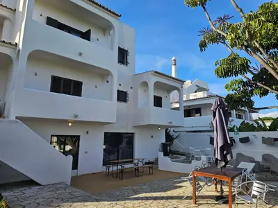a white building with chairs and tables in front of it at Blife Sunya private rooms near airport and nature in Faro