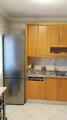 a kitchen with a stainless steel refrigerator and wooden cabinets at Casa Balaia in Olhos de Água