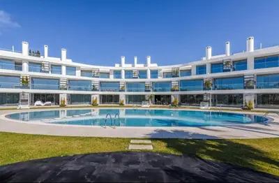 a large building with a swimming pool in front of it at Miami green in Vilamoura