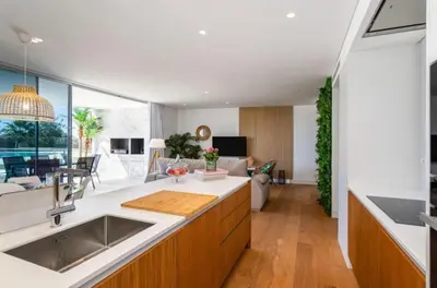 an open kitchen and living room with a large window at Miami green in Vilamoura